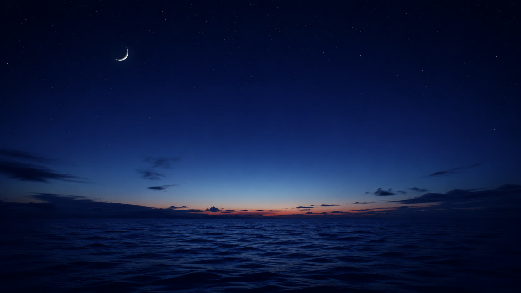 夜の海に浮かぶ細い月。水平線の向こうがわずかに明るみはじめている